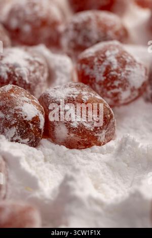 Trockener Kumquat und weißer Puderzucker, süße getrocknete Orangen-Kumquat-Früchte in weißem Puderzucker Stockfoto
