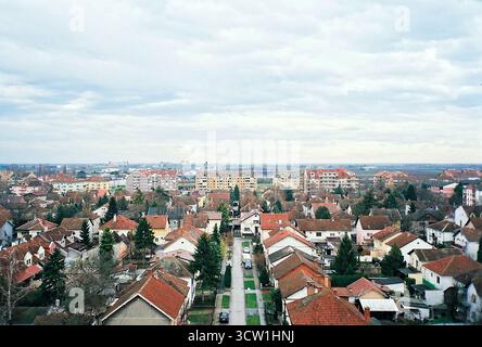 Analoges Foto von einem Balkon eines Gebäudes aus der sozialistischen Ära mit Blick auf ähnliche gelbe Backsteingebäude. Bedeckter Himmel. Dokumentarische Stadtarchitektur Stockfoto