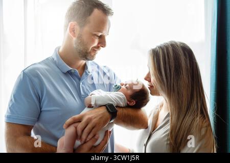 Vater und Mutter im Schlafzimmer mit seinem neugeborenen Sohn Stockfoto