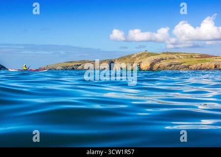 Kajakfahren im Rhoscolyn Beacon vor der Küste von Anglesey / Ynys Mon in Nordwales, Großbritannien Stockfoto