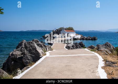 Agios Isidoros kleine Kirche, Insel Chios, Griechenland. Traditionelle Architekturkapelle auf einer felsigen Insel, die durch einen schmalen Betonwalkw mit dem Ufer verbunden ist Stockfoto