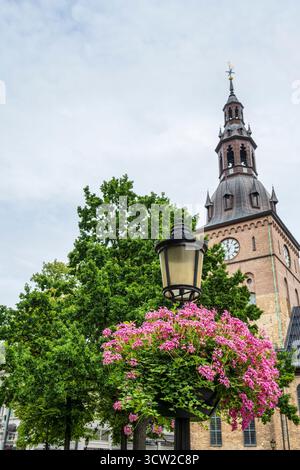 Blumenschmuck am Laternenpfahl vor dem Glockenturm der Kathedrale von Oslo im Zentrum von Oslo, Norwegen, Nordeuropa Stockfoto