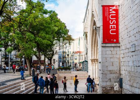 Lissabon, Portugal - 29. Oktober 2022: Eine lebhafte Straßenszene in Lissabon, Portugal, mit dem Archäologischen Museum von Carmo und den geschäftigen Menschenmassen. Stockfoto