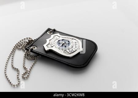 Das Polizeiabzeichen liegt auf einer weißen Oberfläche Stockfoto