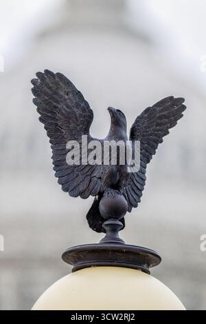 Ulysses S Grant Memorial Adler Licht-Topper Washington DC | WASHINGTON — Ein bronzener Adler als Bekrönung auf einem Grant Memorial-Lampenstiel steht scharf im Fokus vor der sanft verschwommenen Kuppel des U.S. Capitol. Die Pfosten wurden 2019 von den Originalen des Architekten Edward Pearce Casey aus dem Jahr 1922 nachgebildet, wobei jeder aus 16 Gussteilen plus dem Adler bestand; der Bildhauer Henry Merwin Shrady verbrachte seine letzten zwei Jahrzehnte mit dem Denkmal selbst, das am 27. April 1922 eingeweiht wurde. Stockfoto