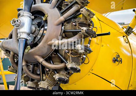 Boeing Stearman N2S-5 Kaydet Engine Chantilly Virginia USA // CHANTILLY, Virginia, Vereinigte Staaten — der Radialmotor und Propeller eines gelben Boeing-Stearman N2S-5 Kaydet-Trainerflugzeugs werden im Steven F. Udvar-Hazy Center ausgestellt. Dieses Doppeldecker war ein wichtiges Trainingsflugzeug für die US Navy während des Zweiten Weltkriegs, das 1943 in Dienst gestellt wurde. Über 10.000 Stearman-Trainer wurden gebaut und bildeten das Rückgrat des Grundflugtrainings der U.S. Army und Navy. Die N2S-5 war Teil der E-75, die eine Standardisierung zwischen den Modellen der Armee (PT-13D) und der Navy erreichte. Dieses Flugzeug ist in Betrieb Stockfoto
