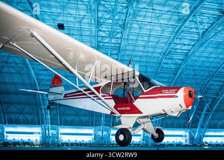 Piper PA-18 Super Cub Atomic Energy Commission Chantilly Virginia // CHANTILLY, Virginia, Vereinigte Staaten — Ein Piper PA-18 Super Cub Flugzeug, rot und cremefarben lackiert mit der „Atomic Energy Commission“ auf dem Rumpf, wird im Steven F. Udvar-Hazy Center ausgestellt. Dieses Hochflügelflugzeug der allgemeinen Luftfahrt 1946 wurde von der AEC in den 1950er Jahren für die Uranforschung im amerikanischen Westen eingesetzt, das wegen seiner niedrigen, langsamen Flugfähigkeit in unebenem Gelände ausgewählt wurde. Ausgestattet mit einem Szintillationszähler im Heck zur Erfassung von Gammastrahlung, ist das Flugzeug Teil der Luftfahrtausstellung des Zweiten Weltkriegs. Das P Stockfoto