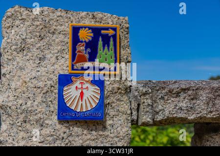 Galicien, Spanien: 23. April 2025: Keramikfliesen auf einer Steinwand, die die Kathedrale von Santiago und die Muschel darstellen, die den Jakobsweg markiert Stockfoto