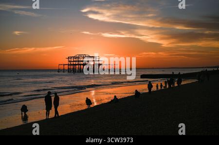 Brighton UK 9. Oktober 2025 - Besucher genießen einen wunderschönen Sonnenuntergang über Brighton Beach und dem West Pier nach einem weiteren warmen Tag entlang der Südküste: Credit Simon Dack / Alamy Live News Stockfoto