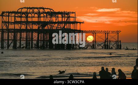 Brighton UK 9. Oktober 2025 - Besucher genießen einen wunderschönen Sonnenuntergang über Brighton Beach und dem West Pier nach einem weiteren warmen Tag entlang der Südküste: Credit Simon Dack / Alamy Live News Stockfoto