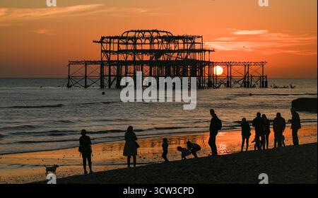 Brighton UK 9. Oktober 2025 - Besucher genießen einen wunderschönen Sonnenuntergang über Brighton Beach und dem West Pier nach einem weiteren warmen Tag entlang der Südküste: Credit Simon Dack / Alamy Live News Stockfoto