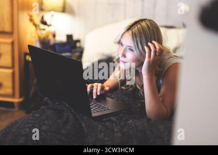 teen macht Hausaufgaben in ihrem Schlafzimmer in einem Haus Stockfoto