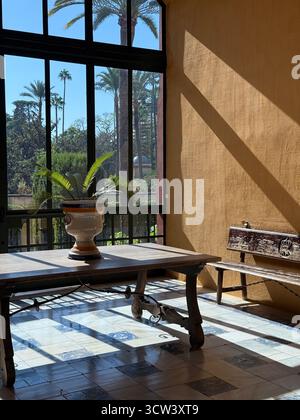 Sevilla, Spanien – 2. Oktober 2025: Sonnendurchfluteter Korridor und Blick auf den Garten im Königlichen Alcázar-Palast Stockfoto