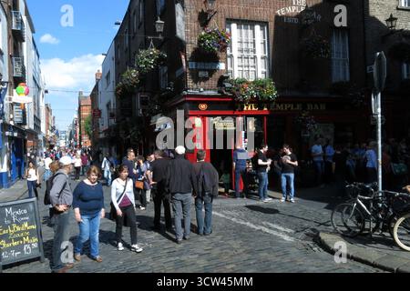 Dublin, Irland - 26. Juni 2015 - Eine lebhafte, geschäftige Szene in der Temple Bar, während die Leute an einem Pub in Dublin vorbeilaufen, das das Straßenleben in der irischen Hauptstadt darstellt Stockfoto
