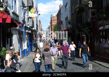 Dublin, Irland - 26. Juni 2015 - Eine lebhafte, geschäftige Szene in der Temple Bar, während die Leute vorbeilaufen, während andere Fotos mit Telefonen in Dublin machen, die das Straßenleben in der irischen Hauptstadt darstellen Stockfoto