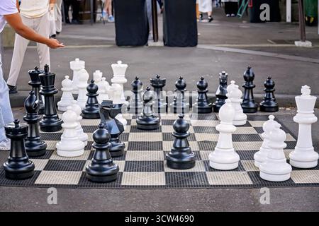 Riesiges Schach in einem Park in einer Stadt, städtisches soziales Strategiespiel und Entspannung, Wochenendvergnügen in der Nachbarschaft Stockfoto
