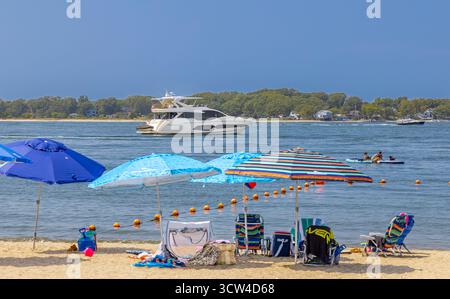 Liegestühle und Sonnenschirme am Sonnenuntergangsstrand Stockfoto