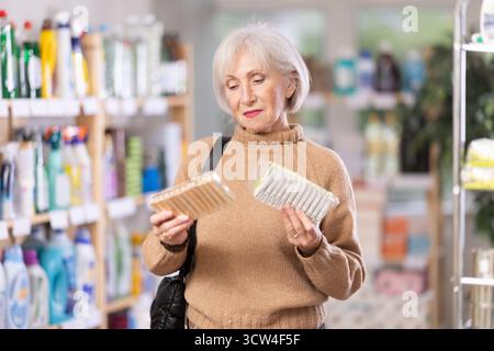 Eine Frau, die sich im Laden eine Wäschespanne ausgesucht hat Stockfoto
