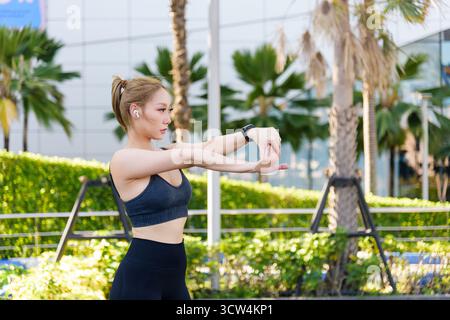 Sport Frau führt Sport-Workout, fit Menschen dehnen sich im Freien, bereiten sich auf Aktivität vor, genießen Stockfoto