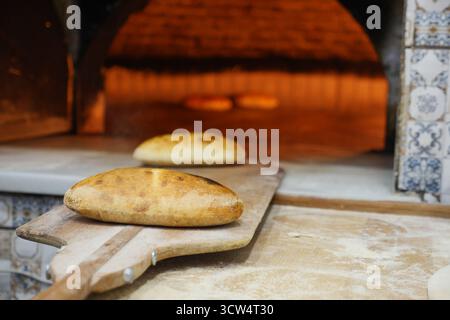 Brotbacken in einem traditionellen Steinofen bei Sonnenuntergang Stockfoto