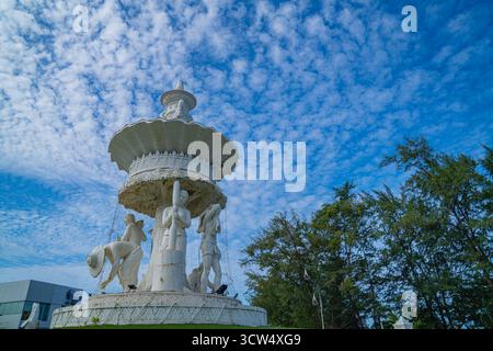 Phuket Thailand. 13. August 2025: Die weiße Skulptur leuchtet in Reinheit, während sich texturierte Wolken über den Himmel erstrecken und eine harmonische Balance zwischen ihnen bilden Stockfoto