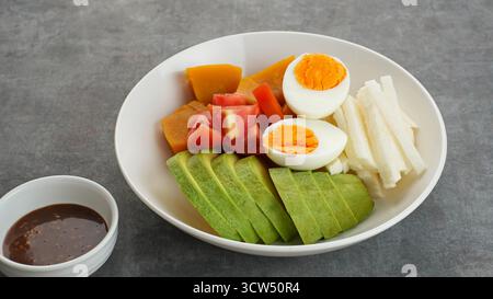 Gesunde Salatschüssel, Gemüse Kürbis, Jicama, Tomaten, Avocado und Ei mit Sesamsauce mischen. Stockfoto