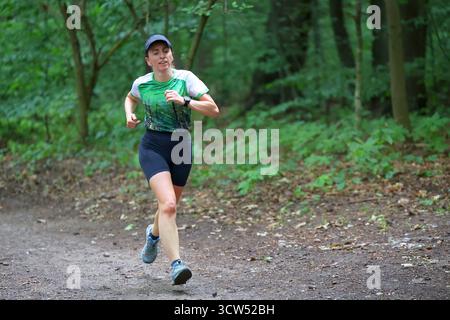 Frau, die auf einem Waldweg läuft Stockfoto