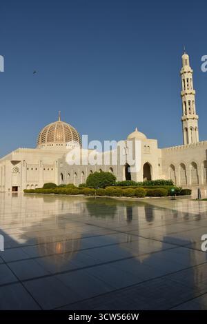 Die Sultan-Qaboos-Moschee in Maskat, die größte Moschee im Oman, spiegelt sich an einem sonnigen Tag in den Marmorfliesen. Stockfoto