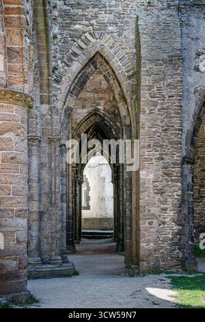 Die Abtei Saint-Mathieu de Fine-Terre in der Bretagne, Frankreich. Das Innere der gotischen Ruine im Sonnenlicht zeigt hohe Bögen und verwitterte Steinsäulen. Stockfoto