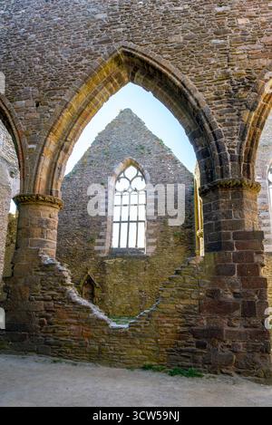 Die Abtei Saint-Mathieu de Fine-Terre in der Bretagne, Frankreich. Das Innere der gotischen Ruine im Sonnenlicht zeigt hohe Bögen und verwitterte Steinsäulen. Stockfoto