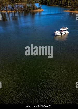 Luftaufnahme der Schleuse Guzianka auf dem Kanal bei Ruciane Nida im Sommer, von oben nach unten gedrehte Drohne, die lebendiges Grün, ruhiges Wasser und Bootstouren einfängt Stockfoto