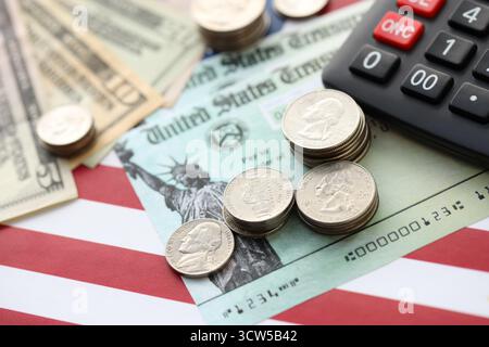 US-Dollar-Geldscheine und Taschenrechner auf amerikanischer Flagge Nahaufnahme. Geldinvestitionskonzept und Steuerzahlung Stockfoto