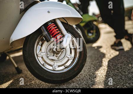 Rom, italien 10. september 2025: Vintage-vespa-Nahaufnahme von Rad, Chrom-Kotflügel und roter Federung im Sonnenlicht auf urbanem Asphalt, Retro Custom det Stockfoto