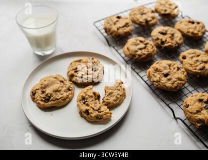 Frisch gebackene Schokoladen-Chip-Cookies mit Milch auf weißem Hintergrund. Stockfoto