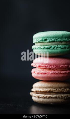 Nahaufnahme von verschiedenen Makkaronkeksen auf schwarzem Hintergrund. Stockfoto