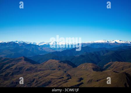 Panoramablick auf die Kaukasus Berge mit schneebedeckten Gipfeln, Hügel unter blauem Himmel. Natürliche Landschaft, die Freiheit, Reinheit und Schönheit der Wildnis symbolisiert Stockfoto