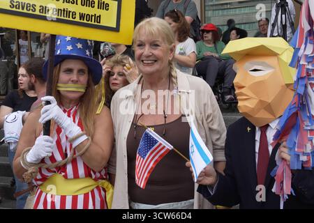 TEL AVIV, ISRAEL - 9. OKTOBER: Eine Frau posiert mit einer Person, die eine Maske trägt, die US-Präsident Donald Trump darstellt, während die Menschen am 9. Oktober 2025 auf dem sogenannten Geiselplatz in Tel Aviv, Israel, die Nachricht vom Gaza-Friedensabkommen feiern und reagieren. Israel und die Hamas haben sich auf die erste Phase eines Waffenstillstandsplans geeinigt, der die Freilassung von Geiseln in Gaza nach ihrer Festnahme am 7. Oktober 2023 in den kommenden Tagen vorsieht. Stockfoto
