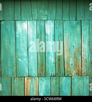 Strukturierte Holzschuppwand mit verwitterter türkisfarbener Farbe, die sich ablöst. Abstrakte minimalistische Komposition, aufgenommen mit Hasselblad 500 cm Filmkamera. Stockfoto