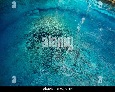 Aus der Vogelperspektive das türkisfarbene Wasser, das über dem felsigen Meeresboden wirbelt, offenbart eine faszinierende Unterwasserlandschaft im Ionischen Meer, Karavomylos, Kefallon Stockfoto