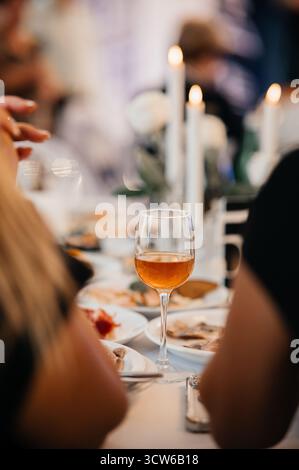Elegantes Abendessen mit Weinglas und wunderschönem Candlelight-Ambiente Stockfoto