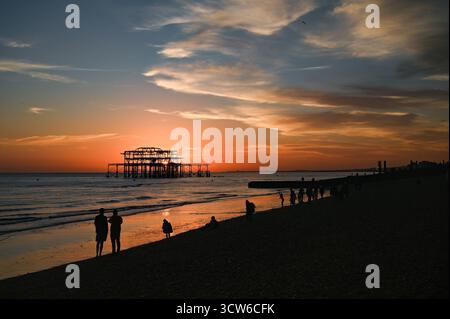Brighton UK 9. Oktober 2025 - Besucher genießen einen wunderschönen Sonnenuntergang über Brighton Beach und dem West Pier nach einem weiteren warmen Tag entlang der Südküste: Credit Simon Dack / Alamy Live News Stockfoto