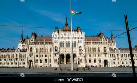 Budapest, Ungarn - 23. April 2018 - ungarisches parlamentsgebäude mit Fahnen und klarem blauem Himmel. Stockfoto