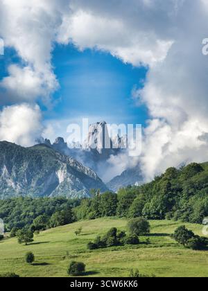 Majestätisches Naranjo de Bulnes Picos Europa - dramatische vertikale Aufnahme des Naranjo de Bulnes (PICU Urriellu) Gipfels, eingerahmt von Wolken und Wald, ein Symbol für Pi Stockfoto