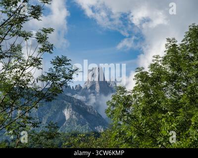 Majestätisches Naranjo de Bulnes Picos Europa - dramatische vertikale Aufnahme des Naranjo de Bulnes (PICU Urriellu) Gipfels, eingerahmt von Wolken und Wald, ein Symbol für Pi Stockfoto