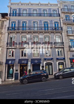 Azulejo-Fliesenfassade mit Balkonen in Lissabon - traditionelle portugiesische Azulejo-Fliesen bedecken eine fünfstöckige historische Gebäudefassade mit Balkonen und gro Stockfoto