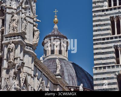 Dom, Campanile und Fassade von Siena Details - Nahaufnahme der komplexen Architektur des Duomo von Siena mit der Laterne der Kuppel, gestreifte Glocke Stockfoto