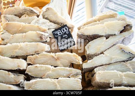 Ein großer Stapel hochwertiger, dickgeschnittener, gesalzener und getrockneter Kabeljau (Bacalhau)-Filets mit handgeschriebenem Preisschild im Mercado do Bolhão in P Stockfoto
