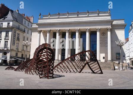 Nantes Theater und Schlangenskulptur - Neoklassizistisches Théâtre Graslin in Nantes, Frankreich, mit moderner Metallskulptur einer Schlange/Brustkorb auf dem Kopfsteinpflaster Stockfoto