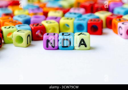 NDA-Text zu mehrfarbigen Würfeln , die die Geheimhaltungsvereinbarung darstellen . Erhaltungskonzept Stockfoto