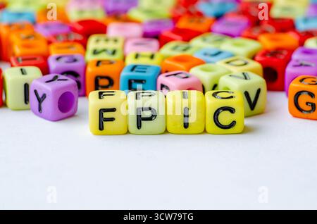 FPIC-Text auf mehrfarbigem Würfel, der die freie, vorherige und informierte Zustimmung darstellt. Erhaltungskonzept Stockfoto